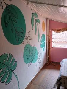 a room with green leaves painted on the wall at Hostel 7 praias in Ubatuba