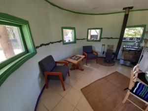 sala de estar con 2 sillas y mesa en Cabaña Casa Morada, en Futaleufú