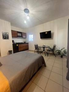 a bedroom with a bed and a table with chairs at Departamentos Yahelik in Cabo San Lucas