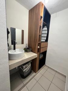 a bathroom with a sink and a wooden cabinet at Departamentos Yahelik in Cabo San Lucas +127 photos