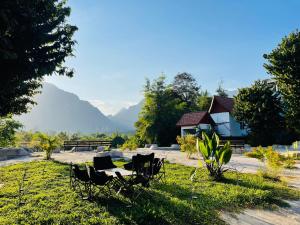 a group of chairs sitting in the grass at Jungle Paradise VangVieng - Bungalows in Vang Vieng