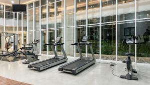 a gym with treadmills and ellipticals in front of a building at Casa de Parco near ICE BSD AEON Mall - Wabi Sabi in Samporo