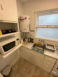 a small kitchen with a sink and a microwave at Depto 2 ambientes Zona Aldrey in Mar del Plata