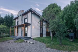 a house with a gravel driveway in front of it at Los Maitenes in San Martín de los Andes