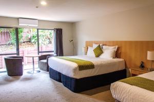 a hotel room with two beds and a window at Greenlane Suites in Auckland
