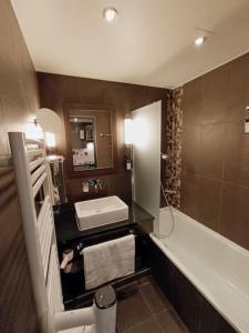 a bathroom with a sink and a tub and a toilet at GREEN Studio climatisé, vue sur golf proche Montpellier in Montpellier
