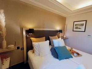 a hotel room with a bed with white and blue pillows at GREEN Studio climatisé, vue sur golf proche Montpellier in Montpellier +22 photos