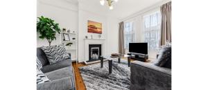 a living room with two couches and a tv at City Escape: Sleek and Comfy 3 BR House w/ Garden in Hither Green