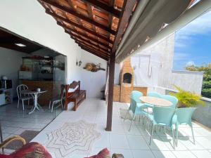 patio con mesa y sillas y cocina en Casa de Vidro Frente ao Mar, en Cabo Frío