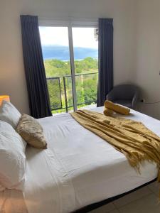 een bed in een kamer met een groot raam bij Beautiful spacious city apartment with views out to the Arafura Sea in Darwin