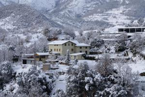 a house covered in snow in a mountain at Casa Masover in Buira
