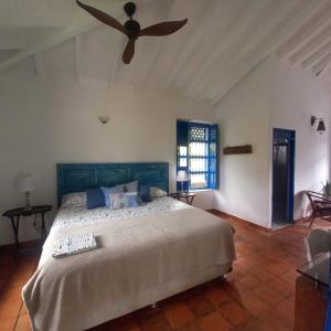 a bedroom with a large bed with a ceiling fan at Hacienda San Francisco in Venecia