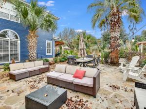 a patio with couches and a table and palm trees at Cozy Oasis in SE Austin in Buda