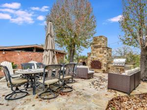 a patio with a table and chairs and an umbrella at Cozy Oasis in SE Austin in Buda