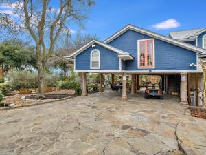 a blue house with a stone driveway at Cozy Oasis in SE Austin in Buda