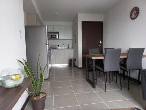 a kitchen and dining room with a table and chairs at Exclusive Apartment, Calzada Roosevelt in Guatemala
