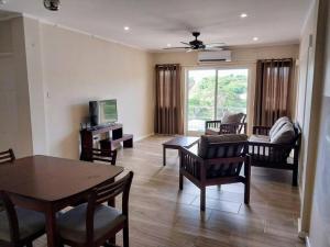 a living room with a table and chairs at 2BR apt near restaurant, beach, nightlife & convenience store in Lance aux Épines