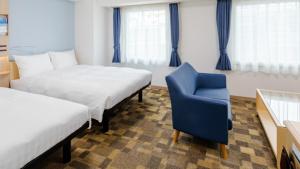 a hotel room with two beds and a blue chair at Toyoko Inn Kokura-eki Kita-guchi in Kitakyushu