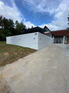 a large white building with a garage at Villa 1317 D’Amour afamosa in Kampong Alor Gajah
