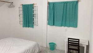 um quarto com uma cama e uma cortina verde em Sueño de bugambilia em Oaxaca de Juárez