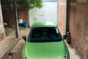 een groene auto geparkeerd naast een gebouw bij Sueño de bugambilia in Oaxaca City