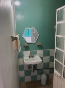 een badkamer met een wastafel en een spiegel bij Sueño de bugambilia in Oaxaca City