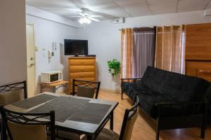 ein Wohnzimmer mit einem schwarzen Sofa und einem Tisch in der Unterkunft 227 Le confort de l'Auberge ! in Trois-Rivières