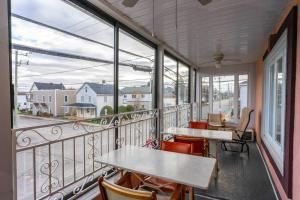 einen Balkon mit Tischen, Stühlen und Fenstern in der Unterkunft 227 Le confort de l'Auberge ! in Trois-Rivières
