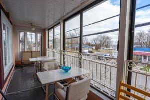 balcón con mesas, sillas y ventanas en 227 Le confort de l'Auberge !, en Trois-Rivières