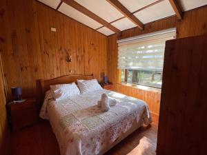 a bedroom with a bed in a room with a window at Cabañas Vista al Lago in La Ensenada
