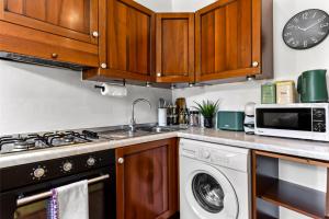 a kitchen with a sink and a stove and a microwave at Vibrant 1 BD Retreat - Perfect for Couples in Hanwell