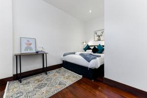 1 dormitorio con 1 cama y mesa auxiliar en Vibrant 1 BD Retreat - Perfect for Couples, en Hanwell