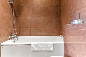 a bathroom with a bath tub and a toilet at Vibrant 1 BD Retreat - Perfect for Couples in Hanwell