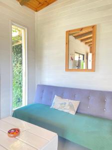 Sofá azul en una habitación con espejo en Mandalas de Mar en Punta Del Diablo