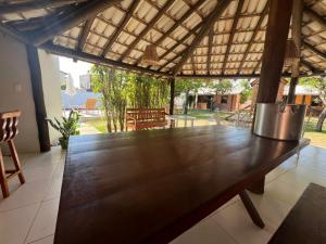 Chalés Coco Verde - Praia de Itacimirim في إيتاسيميريم: طاولة خشبية كبيرة في وسط الفناء