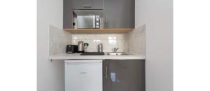 a kitchen with a sink and a microwave at Newly Renovated Cozy Studio in North London in London