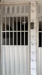 una puerta blanca con barras en un edificio en Apartamento caminho de Moisés, en Maragogi
