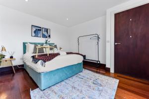 a bedroom with a bed and a wooden door at Fresh and Cosy Two Bedroom Flat in Hanwell