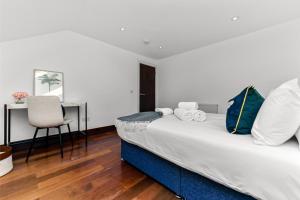 una camera con letto, scrivania e sedia di Fresh and Cosy Two Bedroom Flat a Hanwell
