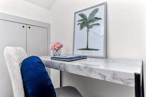 a desk with a picture of a palm tree on it at Fresh and Cosy Two Bedroom Flat in Hanwell