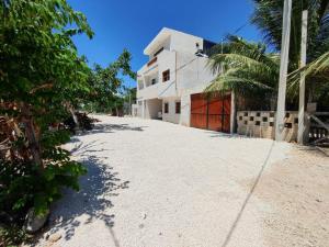 an empty road leading to a white building at Casa bix a beel. in Tulum
