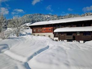 un edificio coperto di neve di fronte di Sachrang: Ferien-Wohnung am See mit Bergblick a Sachrang