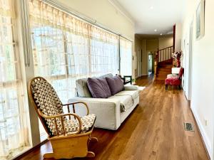 ein Wohnzimmer mit einem Sofa und einem großen Fenster in der Unterkunft Four Seasons Home家四季客栈 in Melbourne
