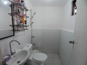 a bathroom with a white toilet and a sink at Transient Home Abucay Bataan - 2 BR in Abucay Hacienda