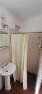 baño con lavabo y cortina de ducha blanca en El mirador de estrellas en Santa Rosa de Calamuchita