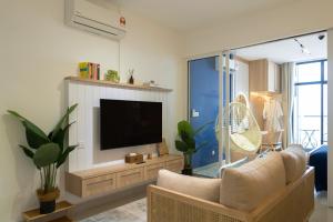 a living room with a couch and a television at The Nest at The Shore KK CBD Seaview with Balcony in Kota Kinabalu