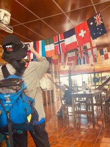 a person with a backpack looking at a flag at Hostal Raíces de mi Pueblo in Suchitoto