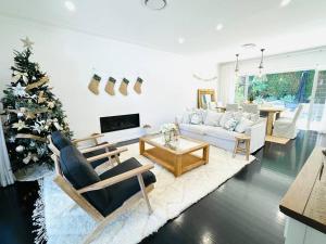 a living room with a christmas tree and a couch at Luxury beachside sanctuary in Adamstown