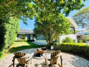 a backyard with two chairs and a table and a fire pit at Luxury beachside sanctuary in Adamstown