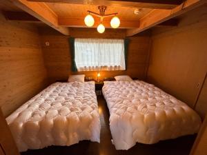 two large beds in a room with a window at 舞鶴ふるるファームコテージ in Maizuru